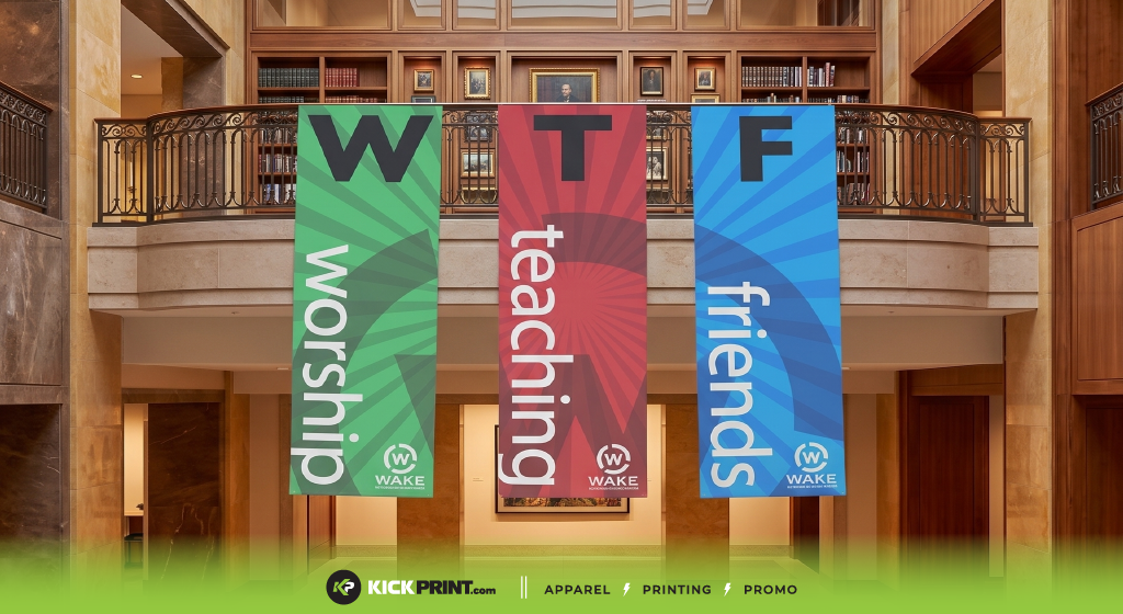 Three large vertical banners hang inside a building, each with a bold letter—W, T, or F—and the words “worship,” “teaching,” and “friends” underneath, unintentionally highlighting one of those embarrassing church design mistakes.