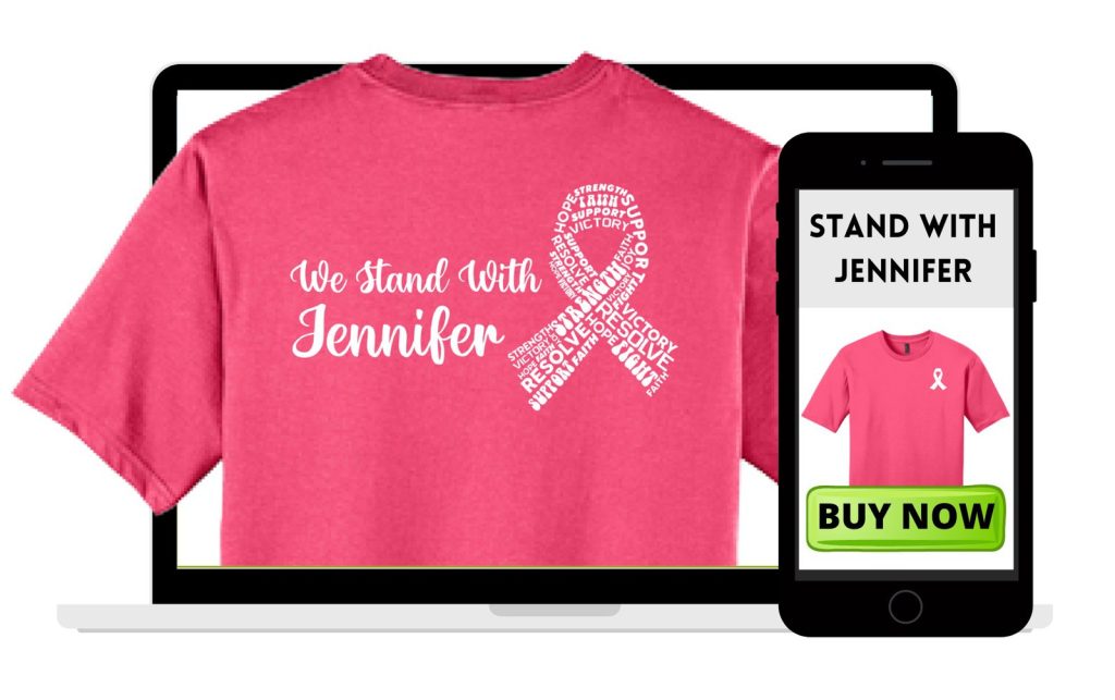 A pink T-shirt with We Stand With Jennifer and a word-filled awareness ribbon is displayed on a laptop screen from a free online store. A phone nearby shows the shirt and STAND WITH JENNIFER above a green BUY NOW button.