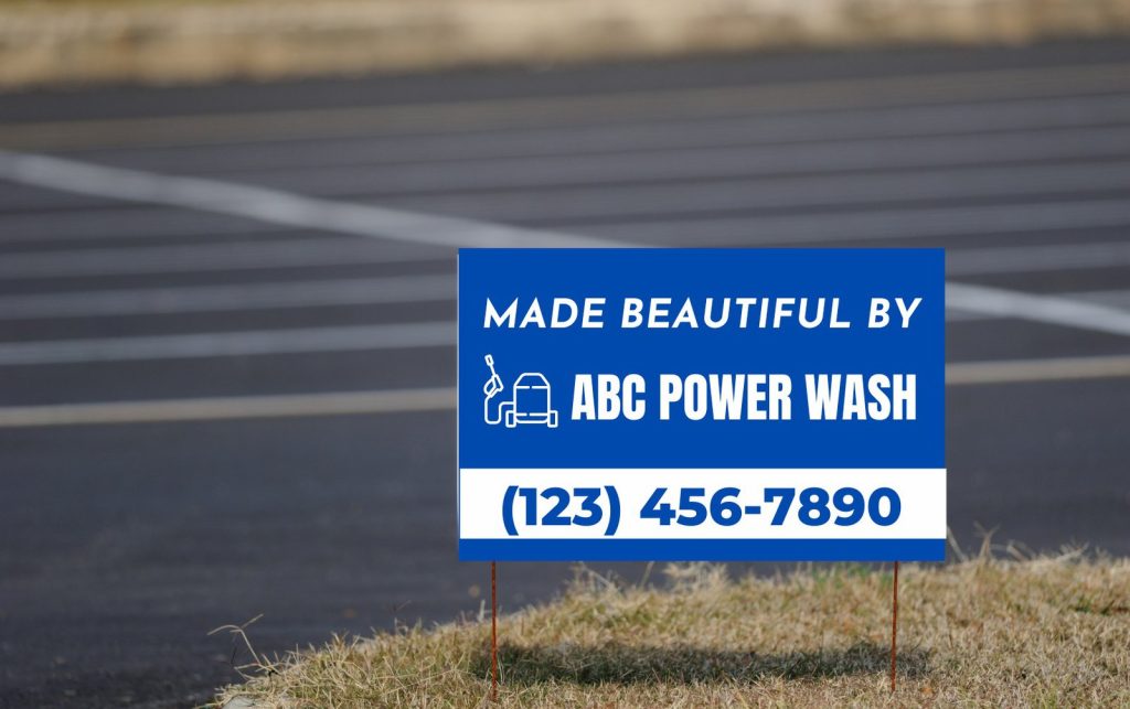 A blue and white Yard Sign reads Made Beautiful By ABC Power Wash with a phone number (123) 456-7890, positioned near a freshly cleaned parking lot. An icon of a power washer is also featured on the sign.