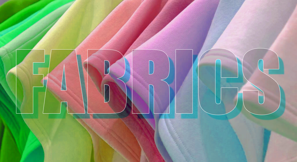 Colorful folded fabrics in green, yellow, pink, purple, and blue hues with the word FABRICS in large transparent letters—perfect inspiration for your next charity event T-shirt or charity event design.