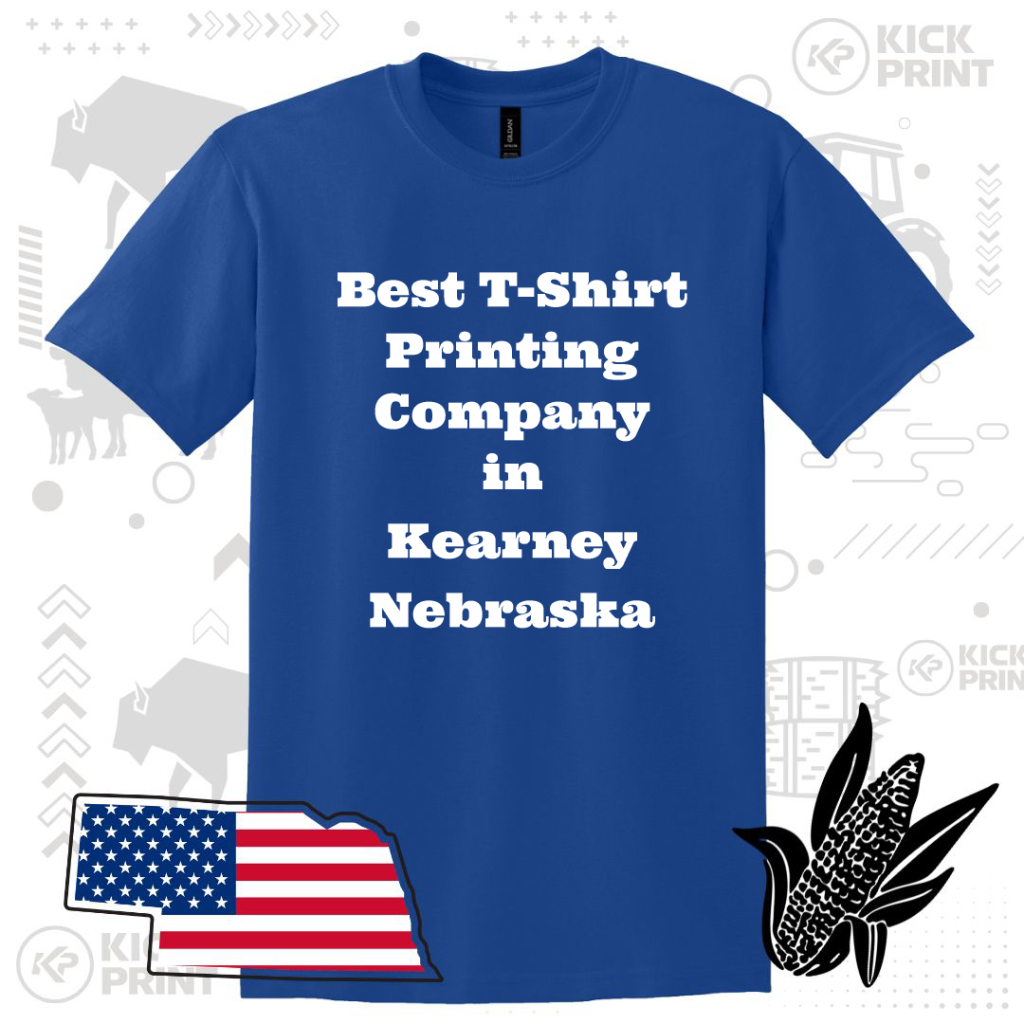 A blue T-shirt with bold white text reading Best T-Shirt Printing Company in Kearney Nebraska, displayed with decorative graphics of Nebraskas outline with a U.S. flag, a black corn icon, and light gray background patterns.