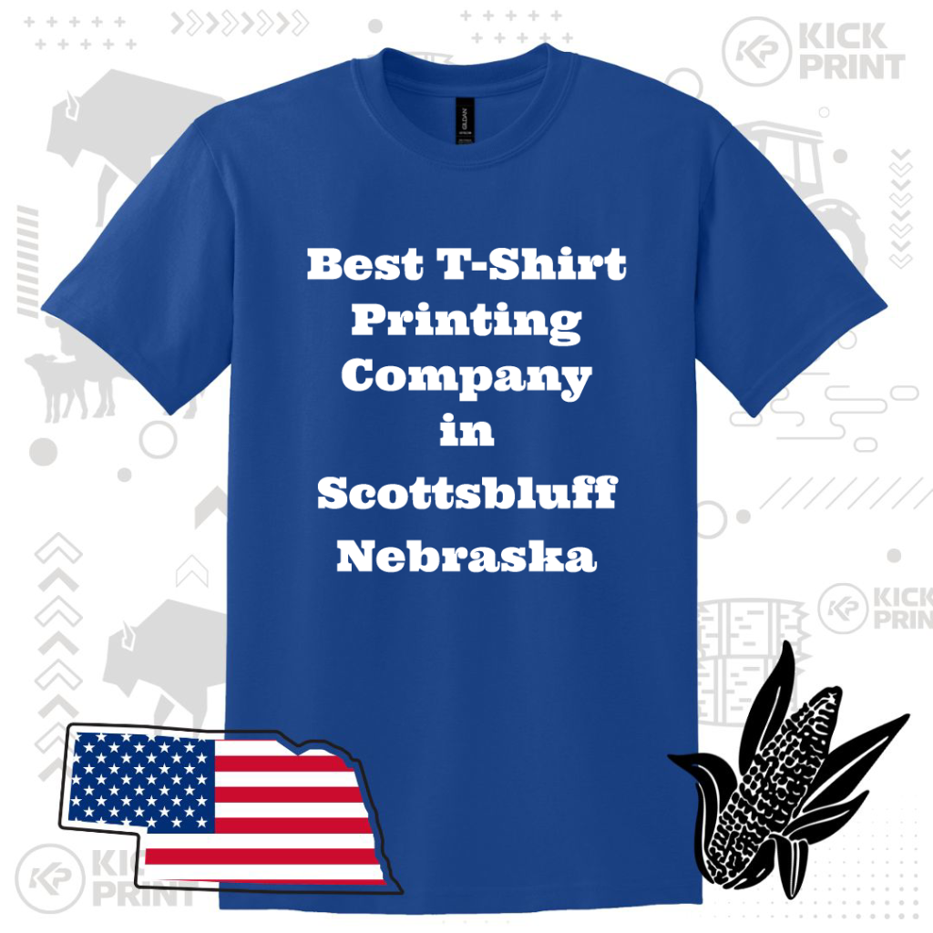 A blue T-shirt displays the white text Best T-Shirt Printing Company in Scottsbluff Nebraska. Background features faint graphics of Nebraska symbols, an American flag in a state shape, and an illustrated ear of corn.