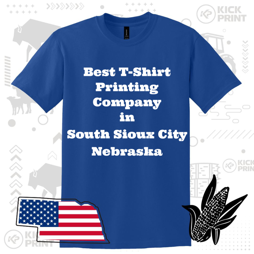 A blue t-shirt with bold white text that reads: Best T-Shirt Printing Company in South Sioux City Nebraska. The background includes an outline of Nebraska with an American flag, a corn graphic, and faint farm-themed icons.