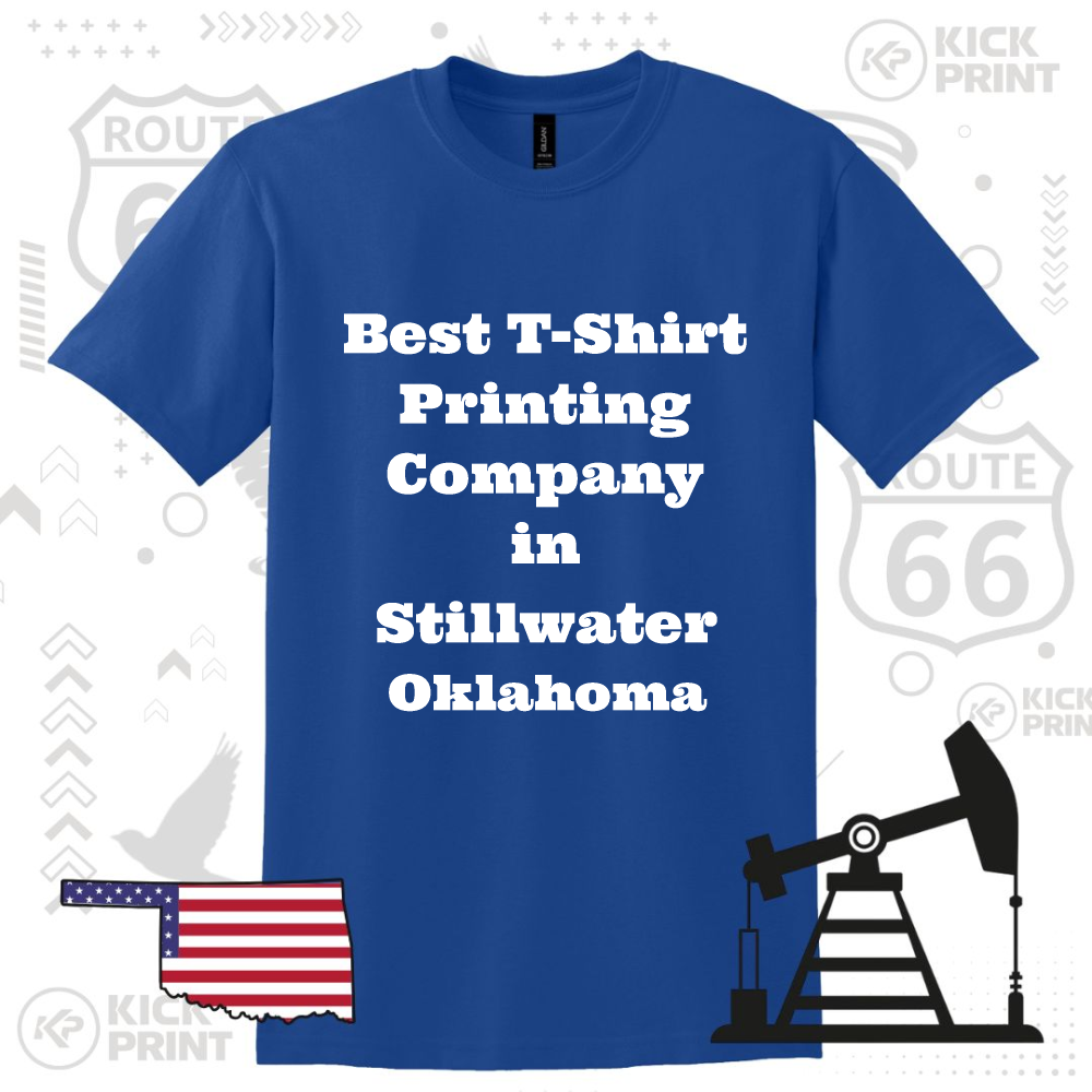 A blue t-shirt displays the text Best T-Shirt Printing Company in Stillwater Oklahoma in bold white letters, with Route 66 signs, an oil pump, and an Oklahoma state graphic in the background.