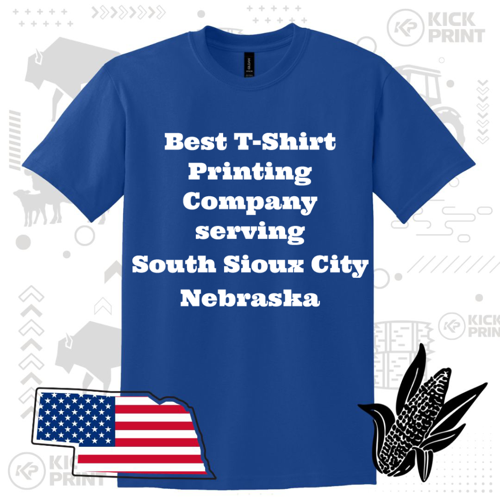A blue T-shirt with white bold text that reads, Best T-Shirt Printing Company serving South Sioux City Nebraska, with graphics of a U.S. flag in Nebraska’s shape and a black corn illustration nearby.