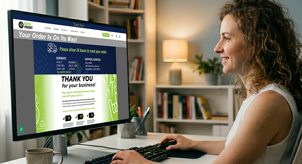 A woman smiles while sitting at a desk and looking at a computer screen displaying an order confirmation message for the Fastest T-Shirt Printing. Shelves and a lamp are visible in the background.